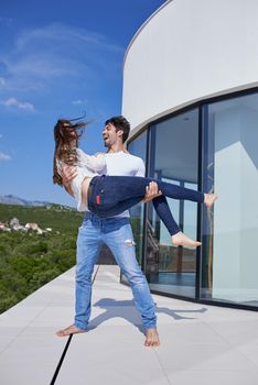 happy young romantic couple have fun relax smile at modern home outdoor terace balcony terace