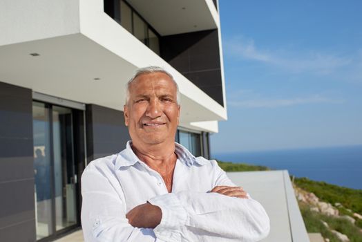 senior man in front of luxury modern home villa