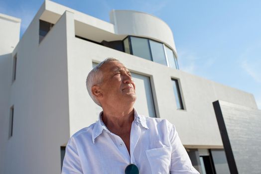 senior man in front of luxury modern home villa
