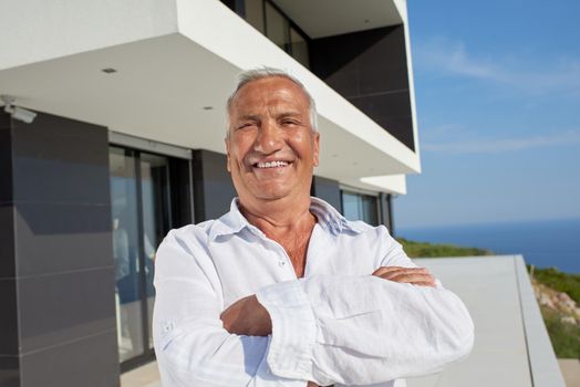 senior man in front of luxury modern home villa