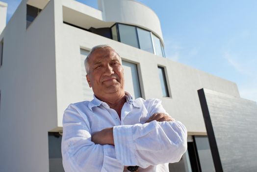 senior man in front of luxury modern home villa