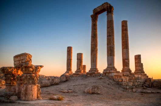 ancient ruins with sun and sunset sky in background (Temple of Hercules in Amman, Jordan)