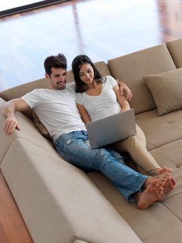 happy young relaxed  couple working on laptop computer at modern home indoor