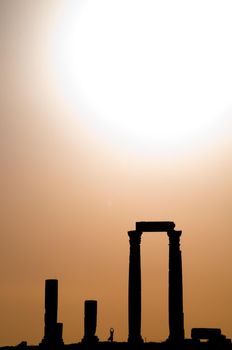 ancient ruins with sun and sunset sky in background (Temple of Hercules in Amman, Jordan)