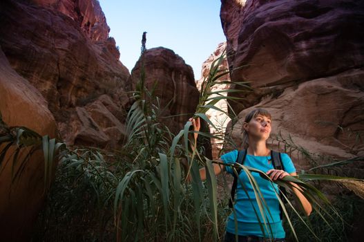 young girl hiking through the deep and narrow canyon