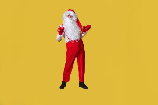 Santa claus yellow food eat background senior man, december happy. Trendy celebrate in suspenders with a large beard
