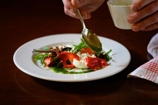 Fresh mozzarella and some paprika get prepared in a fine dining restaurant.
