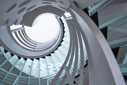 modern glass spiral staircase with metallic hand-rails.