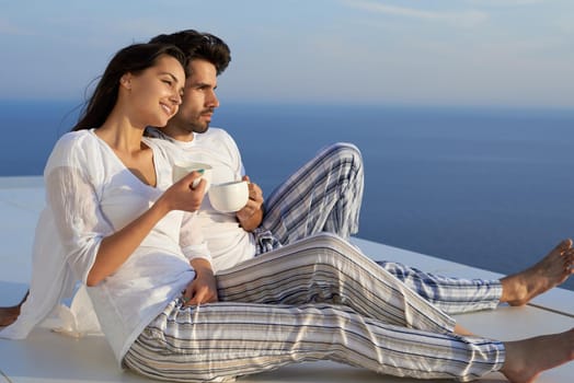 happy young romantic couple have fun relax smile at modern home outdoor terace balcony