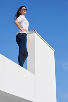 relaxed young beautiful woman in front of luxury modern home villa  on balcony on sunny day