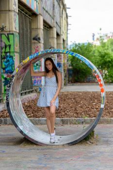 A portrait of a pretty young woman taken in the summertime at a playground in the city.