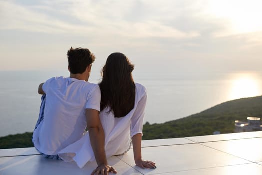 happy young romantic couple have fun relax smile at modern home outdoor terace balcony