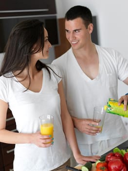 happy young couple have fun in modern kitchen indoor while preparing fresh fruits and vegetables food salad