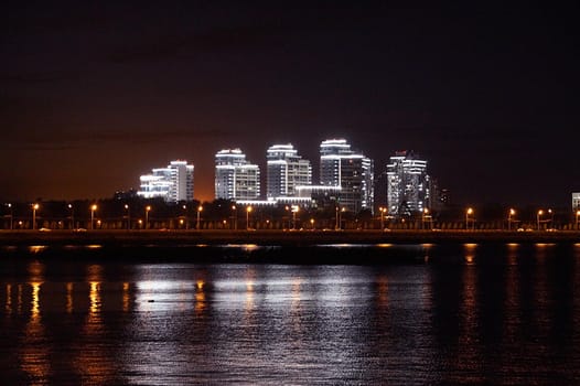 blurred photo, night city lights are reflected in the water, city panorama of Kazan