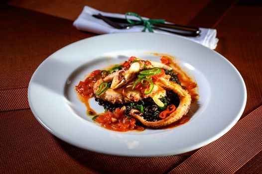 Roasted octopus tentacles with some vegetables in a fine dining restaurant.