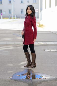 Beautiful chinese woman with long black hair on a sunny autumn day in the city,