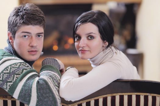 happy Young romantic couple and relaxing sofa in front of fireplace at winter season in home