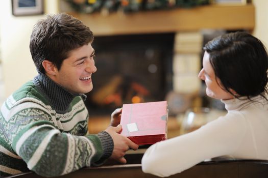 happy Young romantic couple and relaxing sofa in front of fireplace at winter season in home