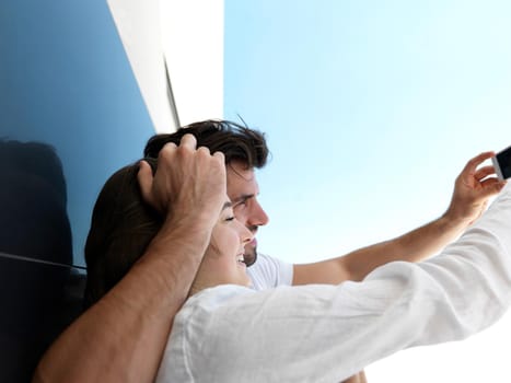 cheerful happy young couple making selfie together at home