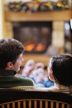 happy Young romantic couple and relaxing sofa in front of fireplace at winter season in home