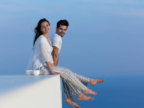 happy young romantic couple have fun relax smile at modern home outdoor terace balcony terace