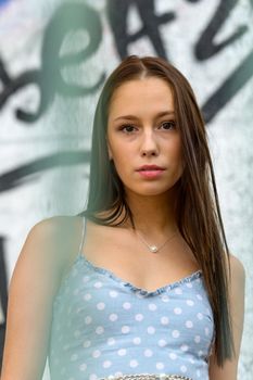 Pretty young woman in an airy summer dress in an urban setting.