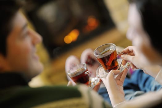 happy Young romantic couple sitting on sofa in front of fireplace at winter season in home