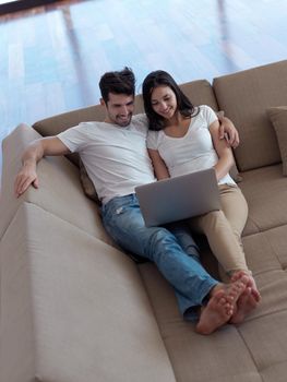 happy young relaxed  couple working on laptop computer at modern home indoor