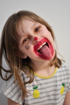 Cute little preschool girl playing with mommy's make up. Fashion experiment little child applying makeup lipstick and shadow on face, staying at home in corona virus quarantine.