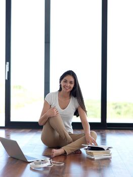 beautiful young woman relax and work on laptop computer modern  home office while listening musin on white headphones