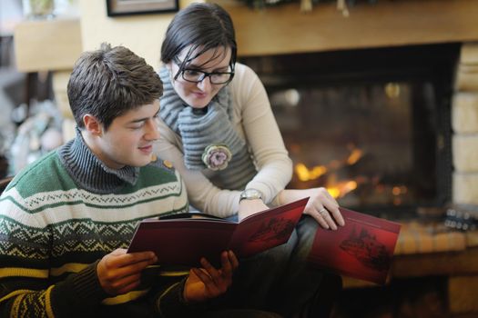 happy Young romantic couple and relaxing sofa in front of fireplace at winter season in home