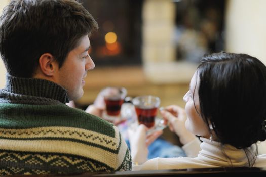 happy Young romantic couple and relaxing sofa in front of fireplace at winter season in home