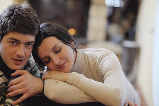 happy Young romantic couple and relaxing sofa in front of fireplace at winter season in home