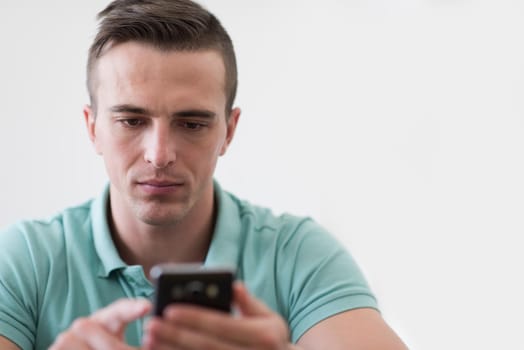 Handsome casual young man using a mobile phone at luxurious home