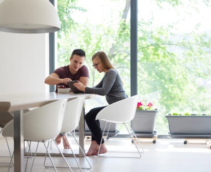 young beautiful handsome couple enjoying morning coffee and strawberries in their luxurious home villa