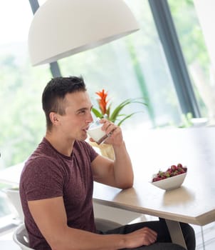 young beautiful handsome couple enjoying morning coffee and strawberries in their luxurious home villa