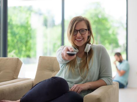 young handsome woman enjoying free time watching television in her luxury home villa