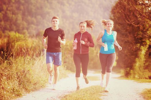 group of young people jogging on country road runners running on open road on a summer day