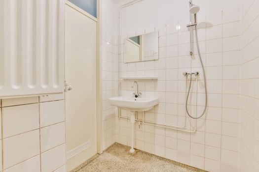 Bathroom with shower and washbasin with white tiles