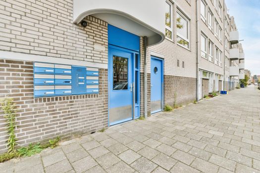 The entrance of the building with a blue door and mailbox