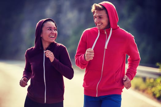 young couple enjoying in a healthy lifestyle while jogging along a country road, exercise and fitness concept