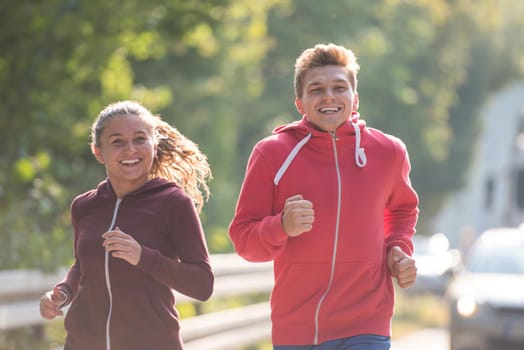 young couple enjoying in a healthy lifestyle while jogging along a country road, exercise and fitness concept