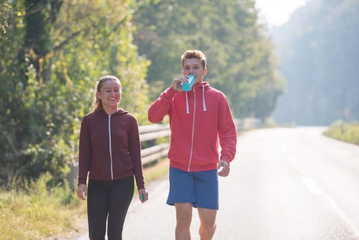 young couple enjoying in a healthy lifestyle while jogging along a country road, exercise and fitness concept