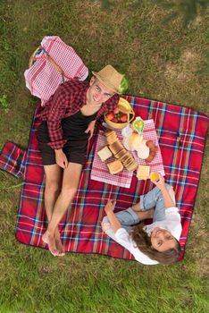 Couple in love enjoying picnic time drink and food in beautiful nature on the river bank top view