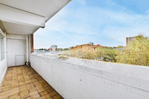 Long narrow balcony with tiled floor and brick handrails