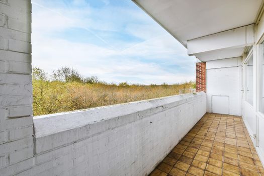 Long narrow balcony with tiled floor and brick handrails