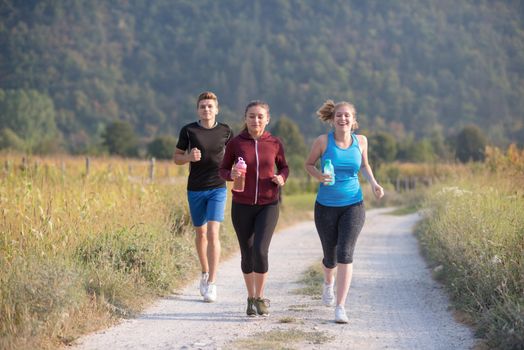 group of young people jogging on country road runners running on open road on a summer day