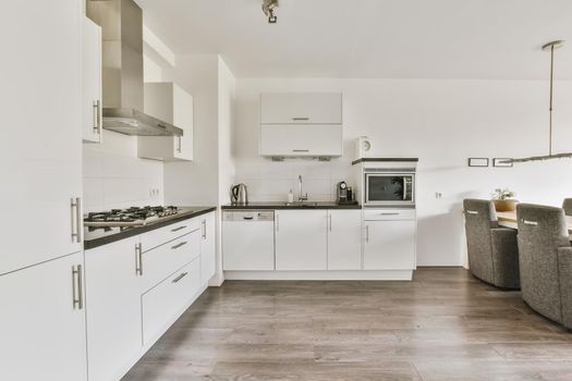 Modern kitchen with white kitchen unit and gray parquet floor