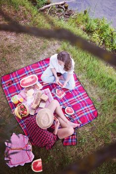 Couple in love enjoying picnic time drink and food in beautiful nature on the river bank top view