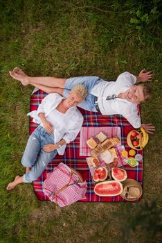 Couple in love enjoying picnic time drink and food in beautiful nature on the river bank top view